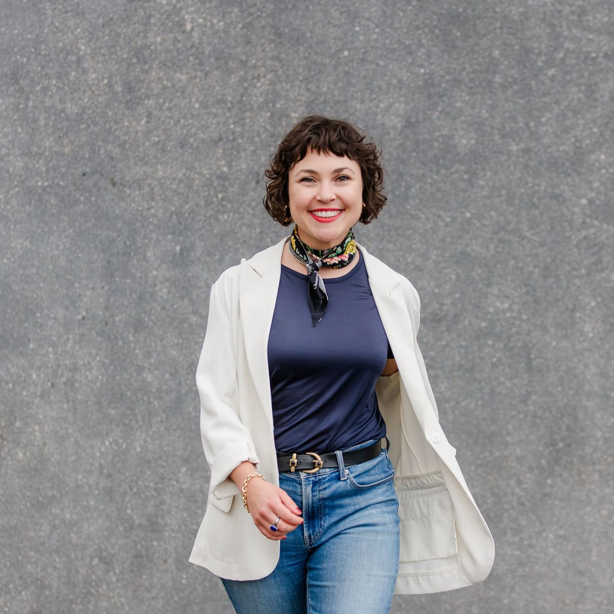 Business-Portrait vor Grau Frau mit kurzem Haar im hellen Blazer und Halstuch vor grauem Hintergrund
