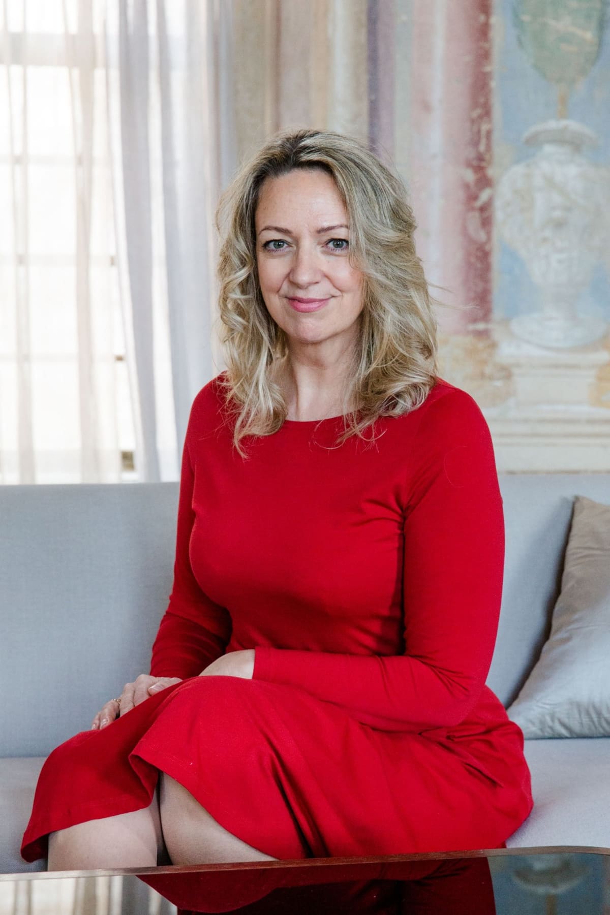 Business-Portrait im Altbau Business-Portrait einer Frau im roten Kleid, sitzend auf einem Sofa in einem hellen Altbau