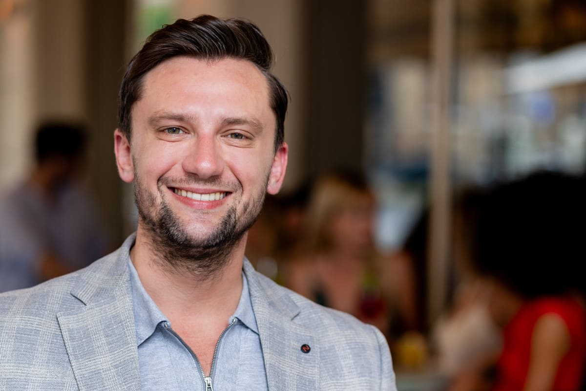 Lächelnder Mann im karierten Sakko in einem Restaurant