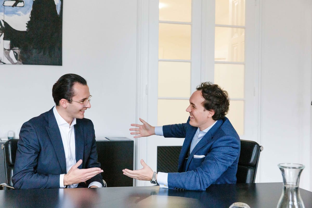 Business-Reportage im Meeting Zwei Männer im Anzug im Gespräch an einem Besprechungstisch