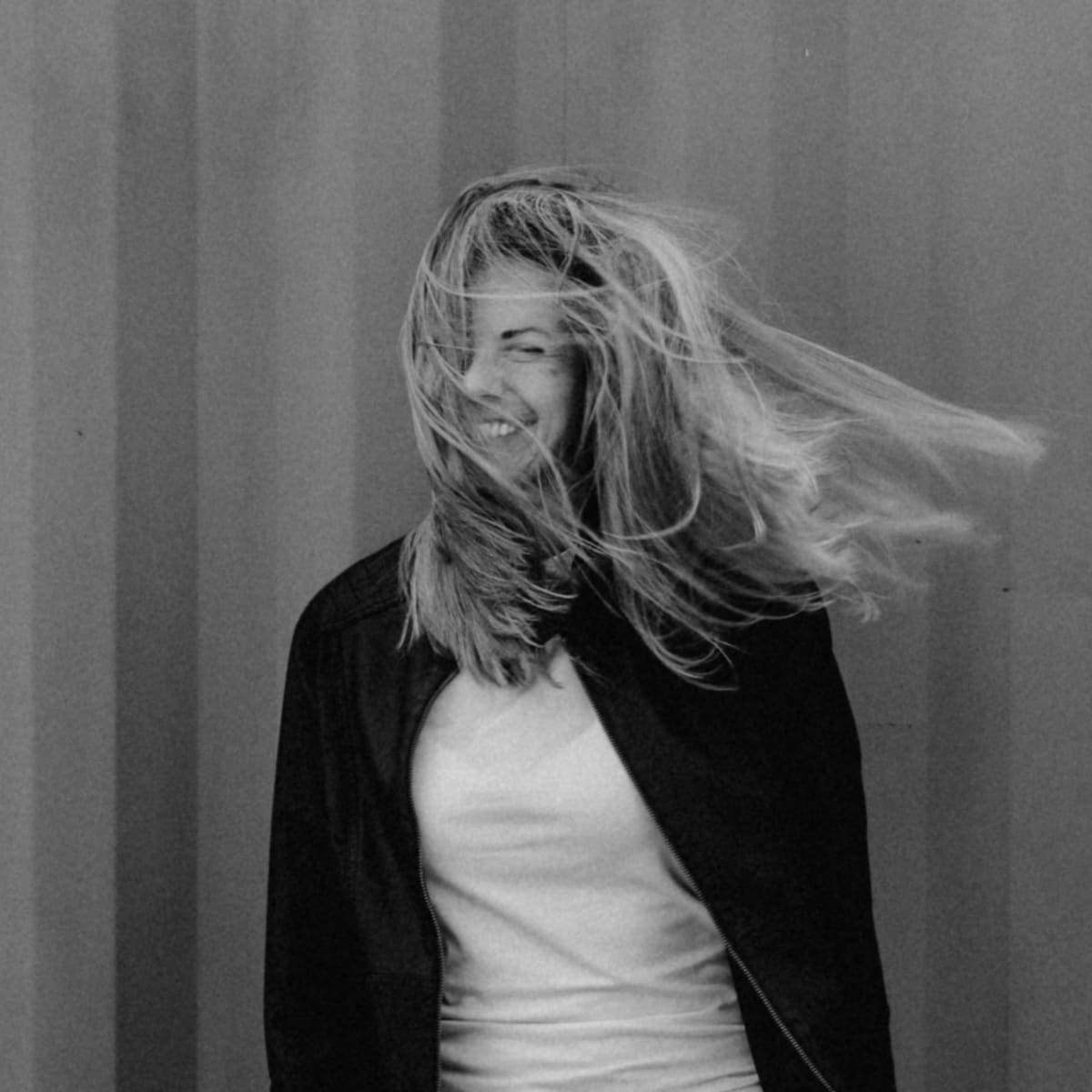 Schwarzweiß-Portrait einer Frau, deren Haare im Wind wehen