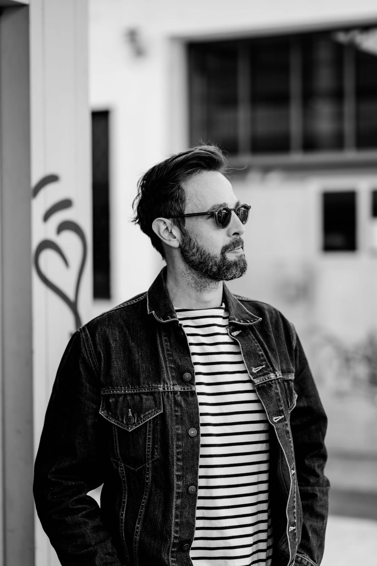 Schwarzweiß-Portrait eines Mannes mit Sonnenbrille und Jeansjacke